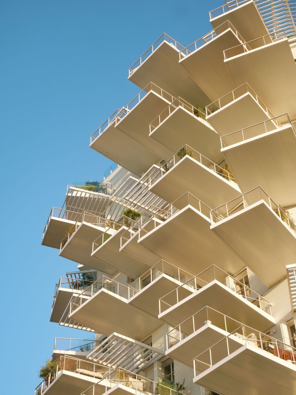 Tiered white cantilevered balconies against a bright blue sky